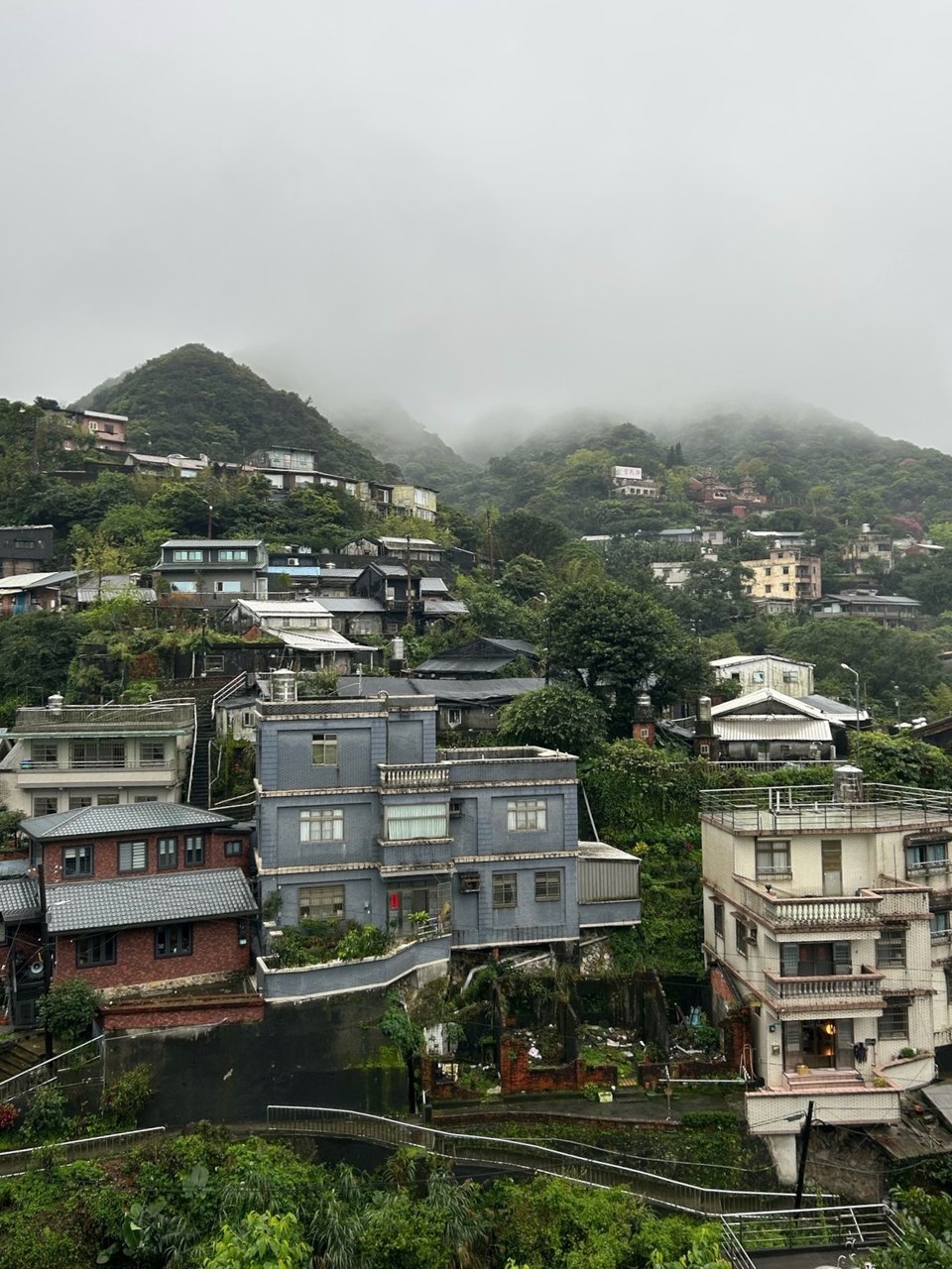 Hillside town beneath low clouds