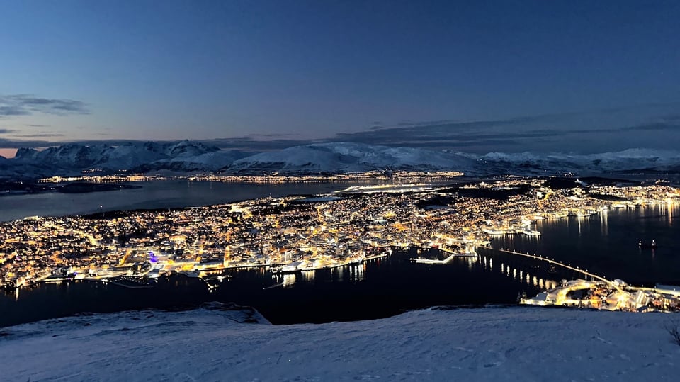 Coastal city lights at dusk seen from above